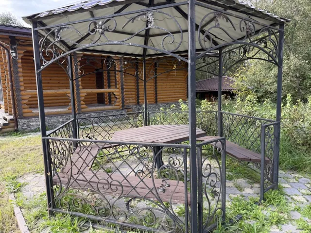 Беседка со столом и скамейками на территории бани