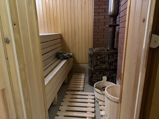 Дровяная печь с камнями и деревянные полки парной