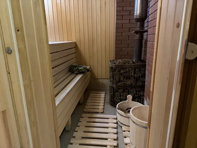 Деревянные полки, печь с камнями и кадушка в парной